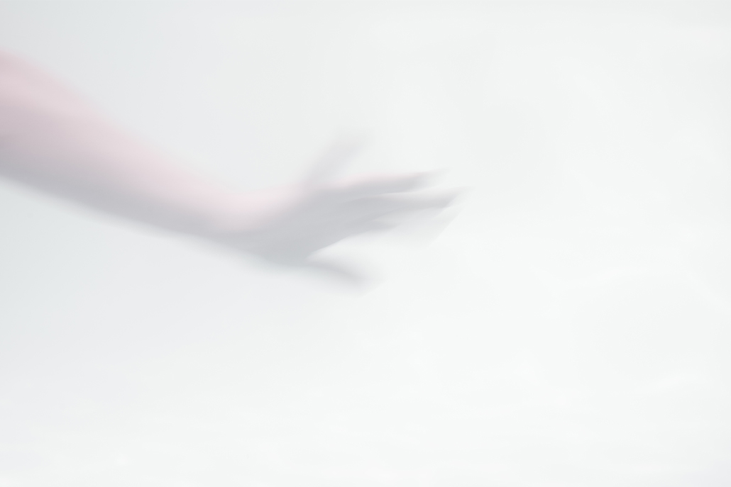﻿Blurry hand reaching over white background